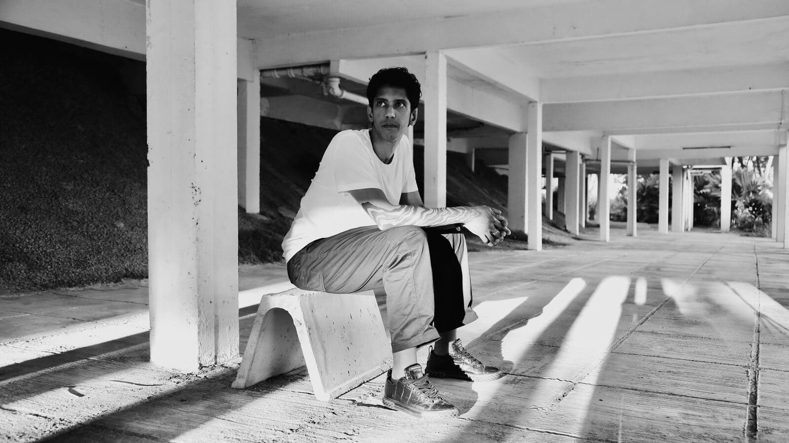 Raul Lee Bhaskaran seated under a concrete colonnade